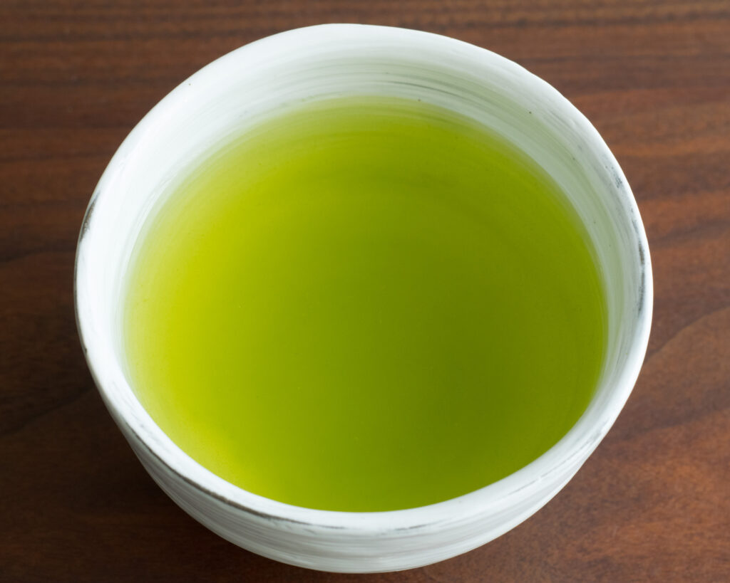 Tazza di sencha giapponese appena infuso, di colore verde brillante